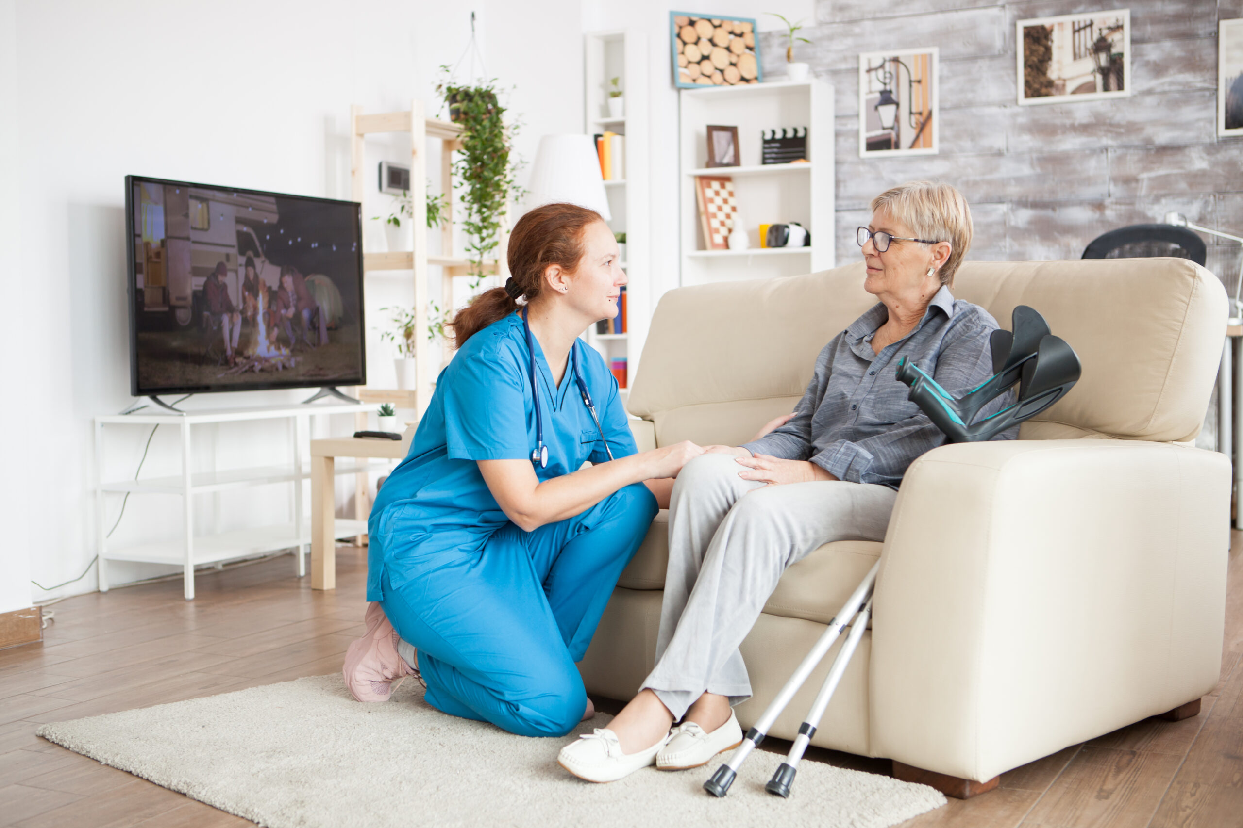 Caregiver holding hands with a senior client at home
